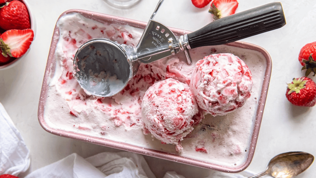 homemade strawberry ice cream mixture being churned in an ice cream maker