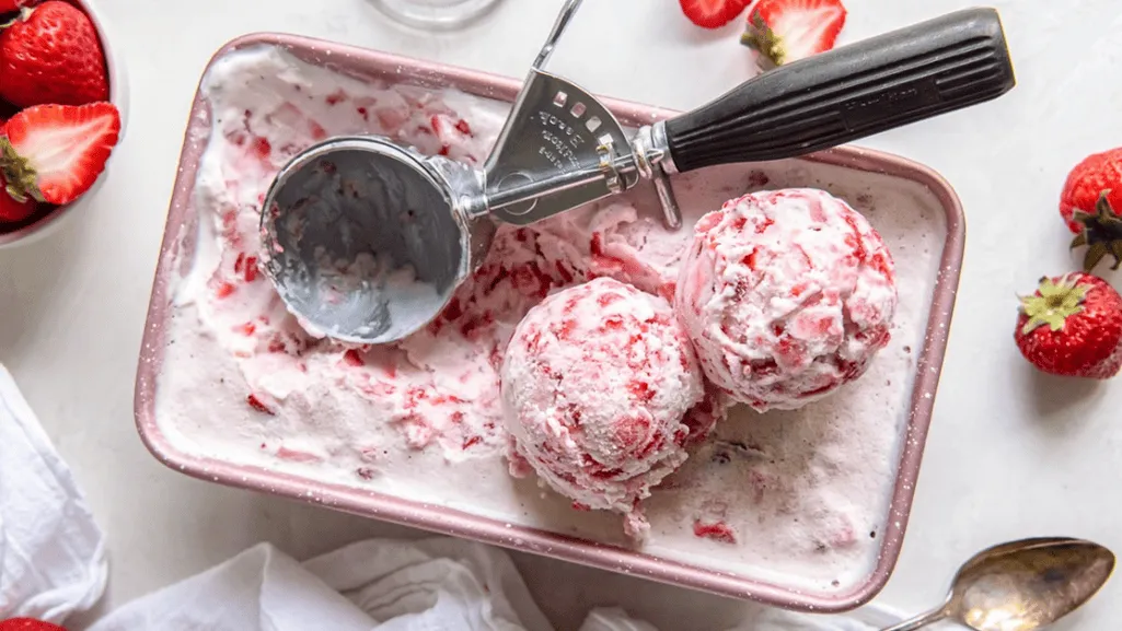 homemade strawberry ice cream mixture being churned in an ice cream maker homemade strawberry ice cream mixture being churned in an ice cream maker