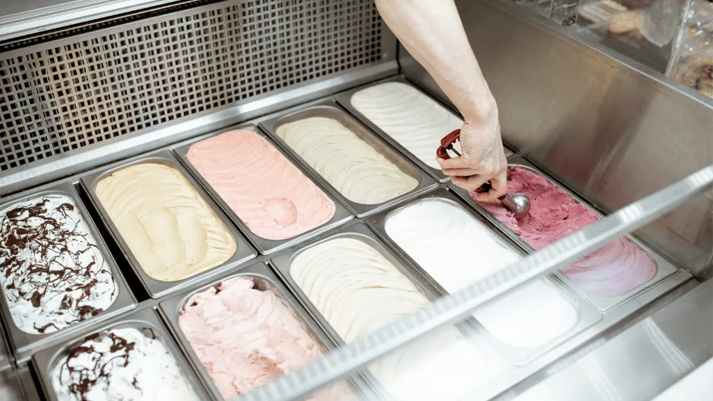 A well-organized freezer interior with meticulously labeled and arranged food items. Soft, diffused lighting illuminates the scene, casting gentle shadows and highlighting the contents. In the foreground, an open freezer drawer reveals neatly stacked containers of ice cream, their surfaces smooth and free of crystallization. The midground showcases a variety of frozen foods, each item labeled with the date and contents. In the background, the freezer shelves are organized with precision, allowing for easy access and efficient storage. The overall atmosphere conveys a sense of order, cleanliness, and attention to detail, exemplifying best practices for freezer storage. How to Store Ice Cream Properly