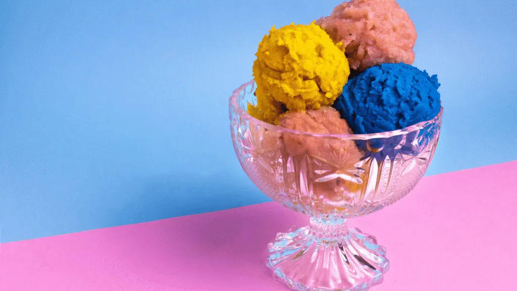 A colorful array of whimsical ice cream scoops in a vintage-inspired ice cream parlor display. In the foreground, a variety of creative flavors including lavender honey, matcha green tea, and salted caramel swirl. The middle ground features an assortment of toppings and mix-ins like chunks of dark chocolate, crushed cookies, and shredded coconut. The background showcases a rustic wooden counter with gleaming chrome accents, evoking an old-fashioned charm. Soft, warm lighting casts a cozy glow, inviting the viewer to imagine the delightful textures and flavors. The overall atmosphere is one of playful, artisanal delight. Old Fashioned Ice Cream Churn Creative Flavor Combinations to Try