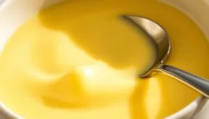 Bowl of custard with a spoon showing the thick, creamy texture achieved without cornstarch