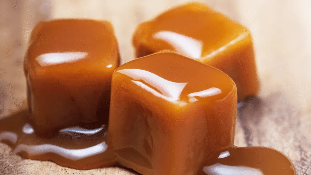 A well-lit, close-up view of a vintage-style ice cream maker and associated tools, arranged on a clean, wooden surface. The machine's brushed metal exterior gleams under soft, directional lighting, highlighting its intricate mechanisms. Surrounding it are various stainless steel utensils, including an ice cream scoop, a hand-cranked churner, and a spatula, all neatly organized. The overall scene conveys a sense of artisanal craftsmanship and attention to detail, perfectly suited for the "Navigating Equipment and Techniques" section of the article on making butterscotch ice cream. Butterscotch Ice Cream Recipe Navigating Equipment and Techniques