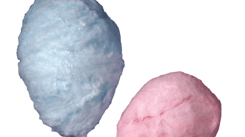 A luscious, close-up view of the essential ingredients for cotton candy ice cream. In the foreground, a pile of soft, pink cotton candy tufts sits atop a scoop of creamy, pale blue ice cream. Behind it, a glass bowl filled with pure white granulated sugar glistens under warm, golden lighting. In the middle ground, a stainless steel mixing bowl contains a vibrant, swirling blend of pastel food coloring. In the background, a vintage-inspired ice cream scoop and a stack of waffle cones evoke a nostalgic, old-fashioned ambiance. The overall scene exudes a playful, whimsical charm, inviting the viewer to indulge in the sweetness of homemade cotton candy ice cream. Ingredient Guide for Your Cotton Candy Ice Cream Recipe