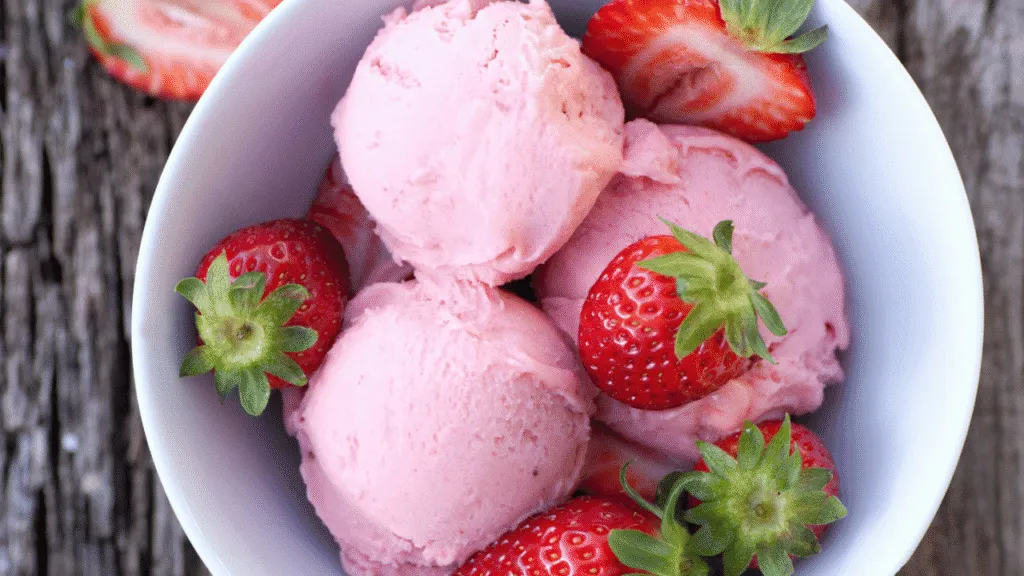 A delectable scoop of strawberry ice cream, its vibrant pink hue glistening under a soft, natural light. The luscious texture is captured in creamy, swirling peaks, hinting at the perfect balance of sweetness and tang. In the background, a subtle gradient fades from a soft, pastel pink to a deeper, almost crimson shade, creating a sense of depth and dimension. The overall composition evokes a sense of classic, artisanal indulgence, inviting the viewer to savor the perfect combination of flavor and texture. Classic Strawberry Ice Cream Recipe Pro tips for flavor, texture, and perfect churn results
