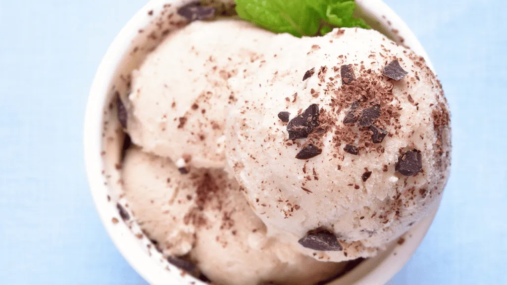 A step-by-step guide for making homemade Cookies and Cream ice cream. The foreground shows a marble countertop with a classic ice cream maker, scoops, and a bowl of freshly churned ice cream. In the middle ground, detailed instructions are displayed on parchment paper, with images illustrating each step. The background features a rustic kitchen setting, with wooden shelves, jars of ingredients, and a vintage-inspired tile backsplash. The lighting is soft and natural, creating a warm, inviting atmosphere. The overall mood is one of nostalgia and the joy of creating a delicious, homemade treat. A step-by-step guide for making homemade Cookies and Cream ice cream. The foreground shows a marble countertop with a classic ice cream maker, scoops, and a bowl of freshly churned ice cream. In the middle ground, detailed instructions are displayed on parchment paper, with images illustrating each step. The background features a rustic kitchen setting, with wooden shelves, jars of ingredients, and a vintage-inspired tile backsplash. The lighting is soft and natural, creating a warm, inviting atmosphere. The overall mood is one of nostalgia and the joy of creating a delicious, homemade treat.
