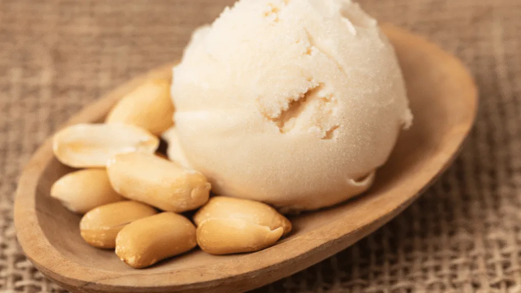 a closeup high-resolution photograph of a glass jar filled with rich, creamy coconut milk. The milk has a smooth, silky texture and a pale, off-white color. Gentle lighting from the side creates soft shadows and highlights the luscious, velvety appearance of the liquid. The jar is positioned on a simple, minimalist surface, allowing the coconut milk to be the focal point. The background is blurred and clean, creating a serene, appetizing atmosphere that evokes a sense of purity and indulgence.